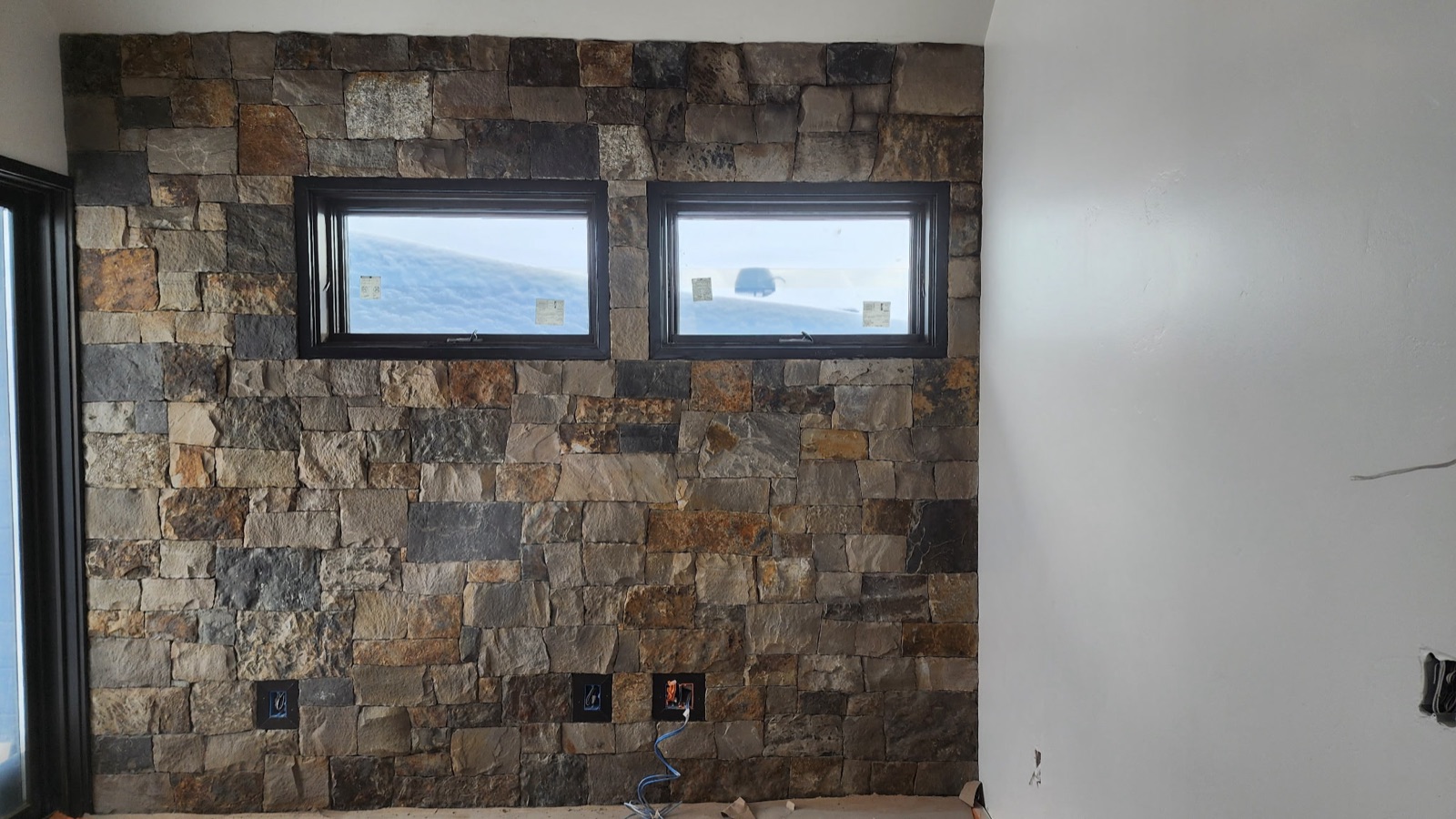 Interior squared-stone accent wall between two windows