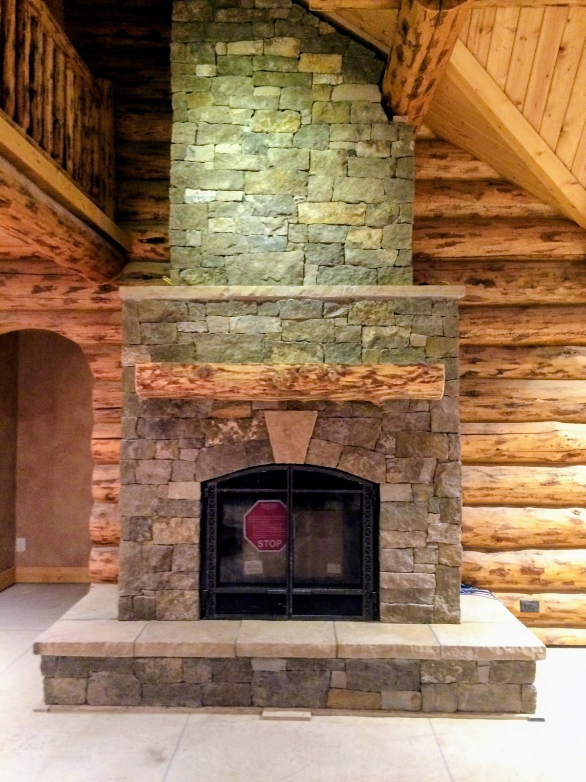 Stone fireplace and log walls in a Yampa Valley log home great room