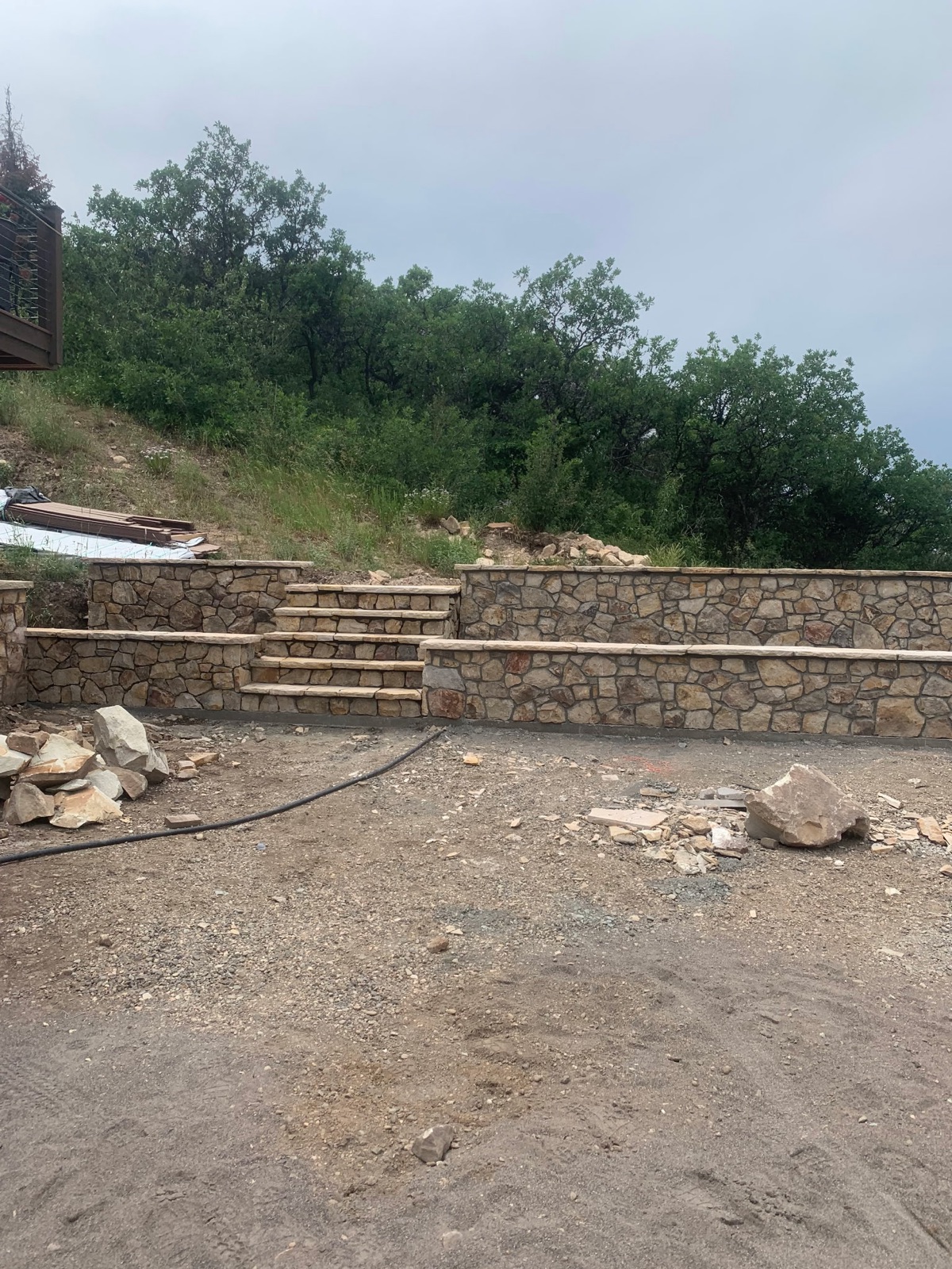 Terraced stone retaining walls with integrated stone stairs on a hillside