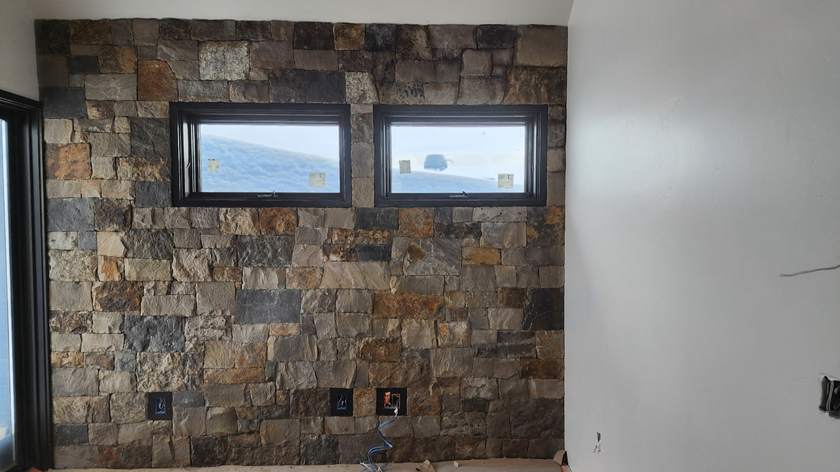 Interior squared-stone accent wall between two windows